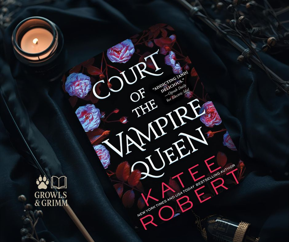 Flat lay of Court of the Vampire Queen by Katee Robert surrounded by candles and gothic accents, evoking a dark-fantasy romance atmosphere Growls and Grimm